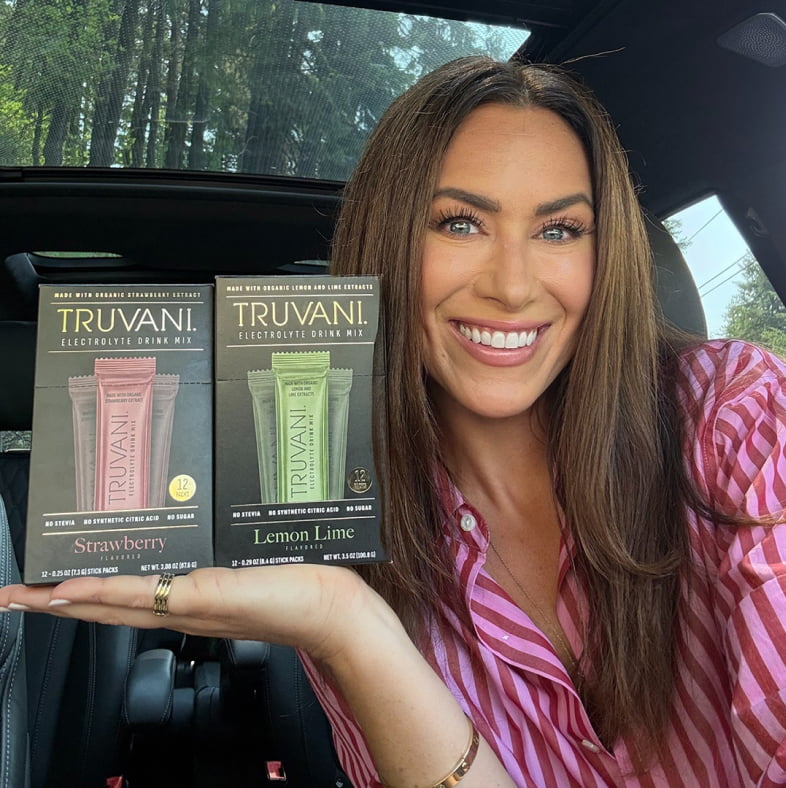 Holding Truvani Strawberry and Lemon Lime electrolyte drink mix boxes
